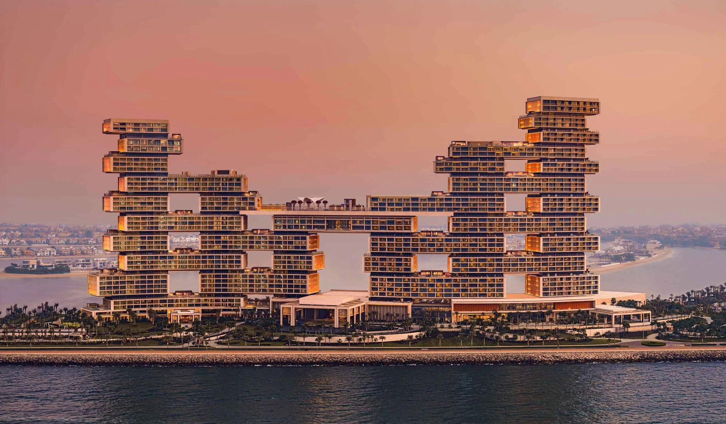Sunset view of Atlantis The Royal on Palm Jumeirah with Dubai’s waterfront skyline glowing in golden evening light