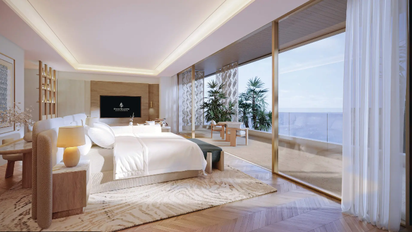 Luxury beachfront bedroom with floor-to-ceiling windows overlooking the Arabian Gulf.