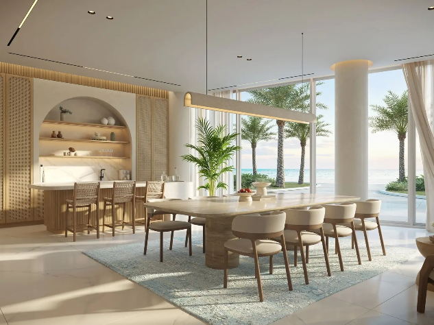 Luxury waterfront foyer with sculptural table styling overlooking palm trees and the beachfront.