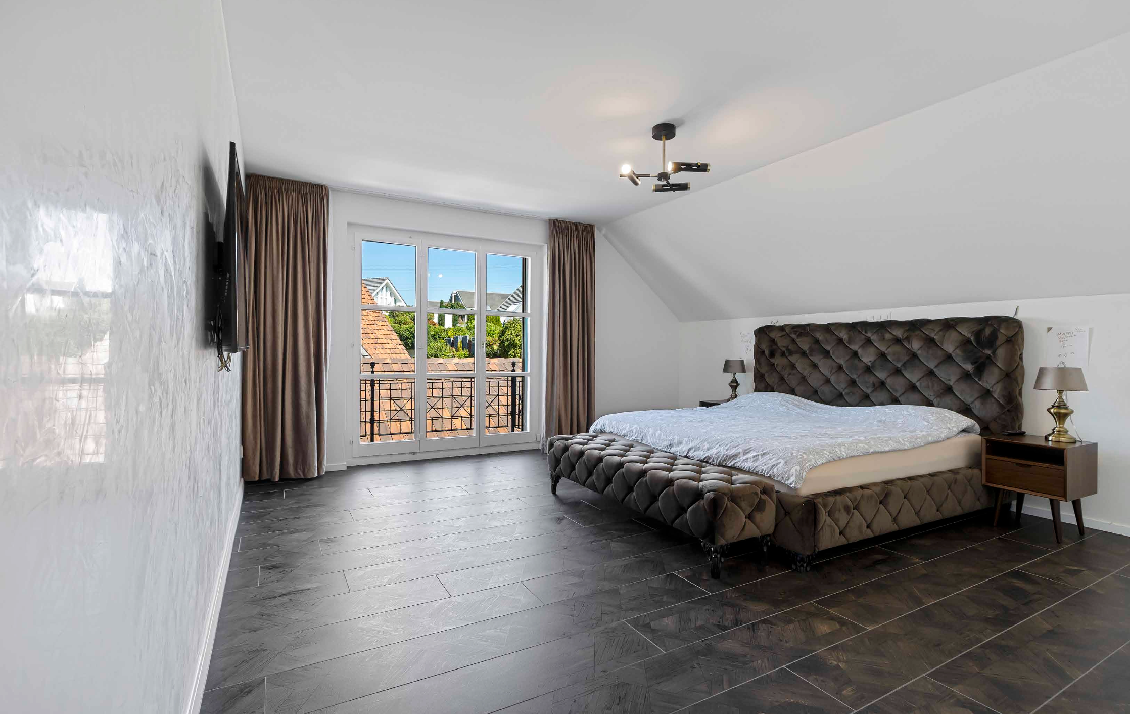 Luxury bedroom suite with soft neutral interiors and countryside residential views.