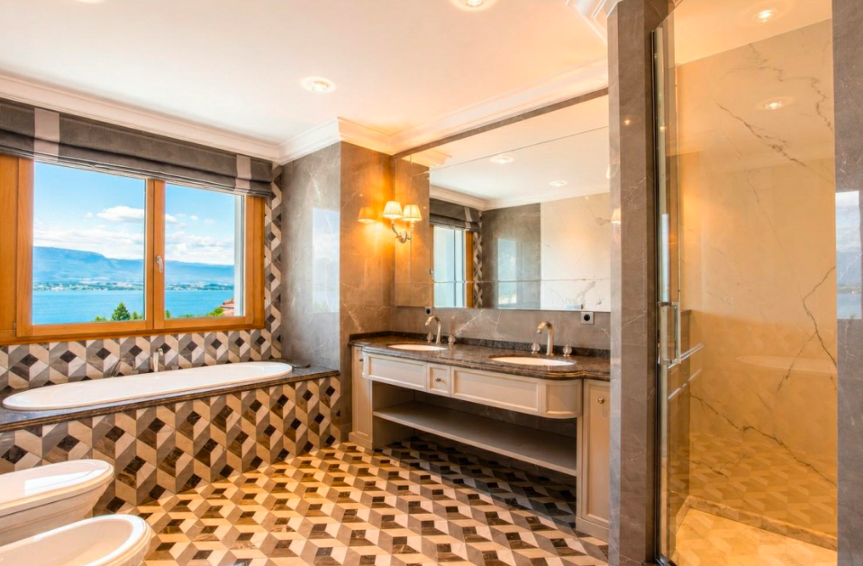 Luxury marble bathroom with premium finishes overlooking Lake Geneva and the surrounding Alpine landscape.
