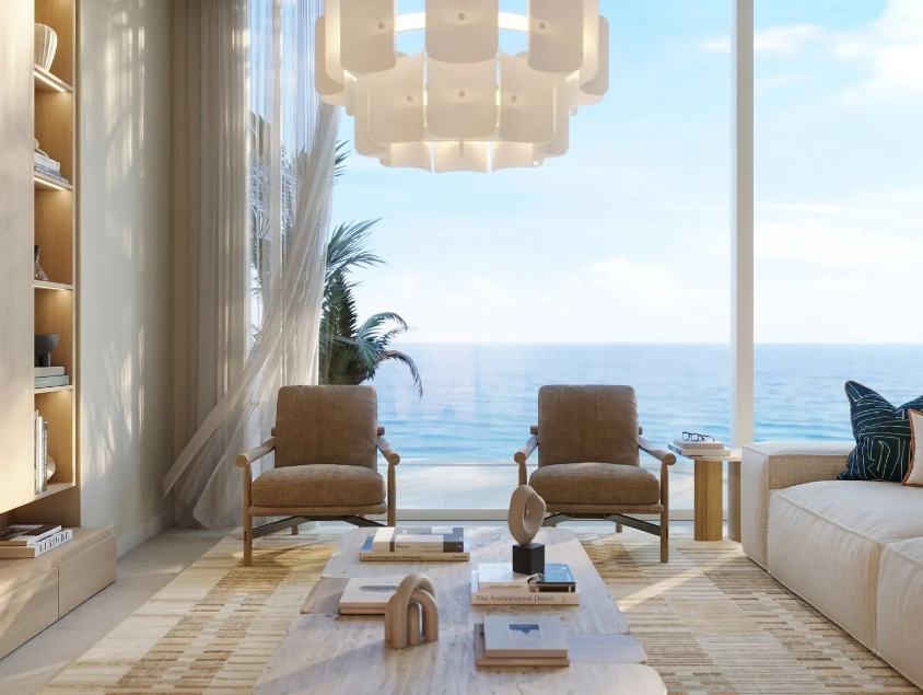 Luxury waterfront living room with floor-to-ceiling windows overlooking the sea in Abu Dhabi.