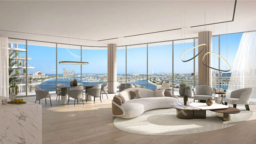 Open-plan waterfront living room with floor-to-ceiling windows overlooking Palm Jumeirah and the Dubai skyline.